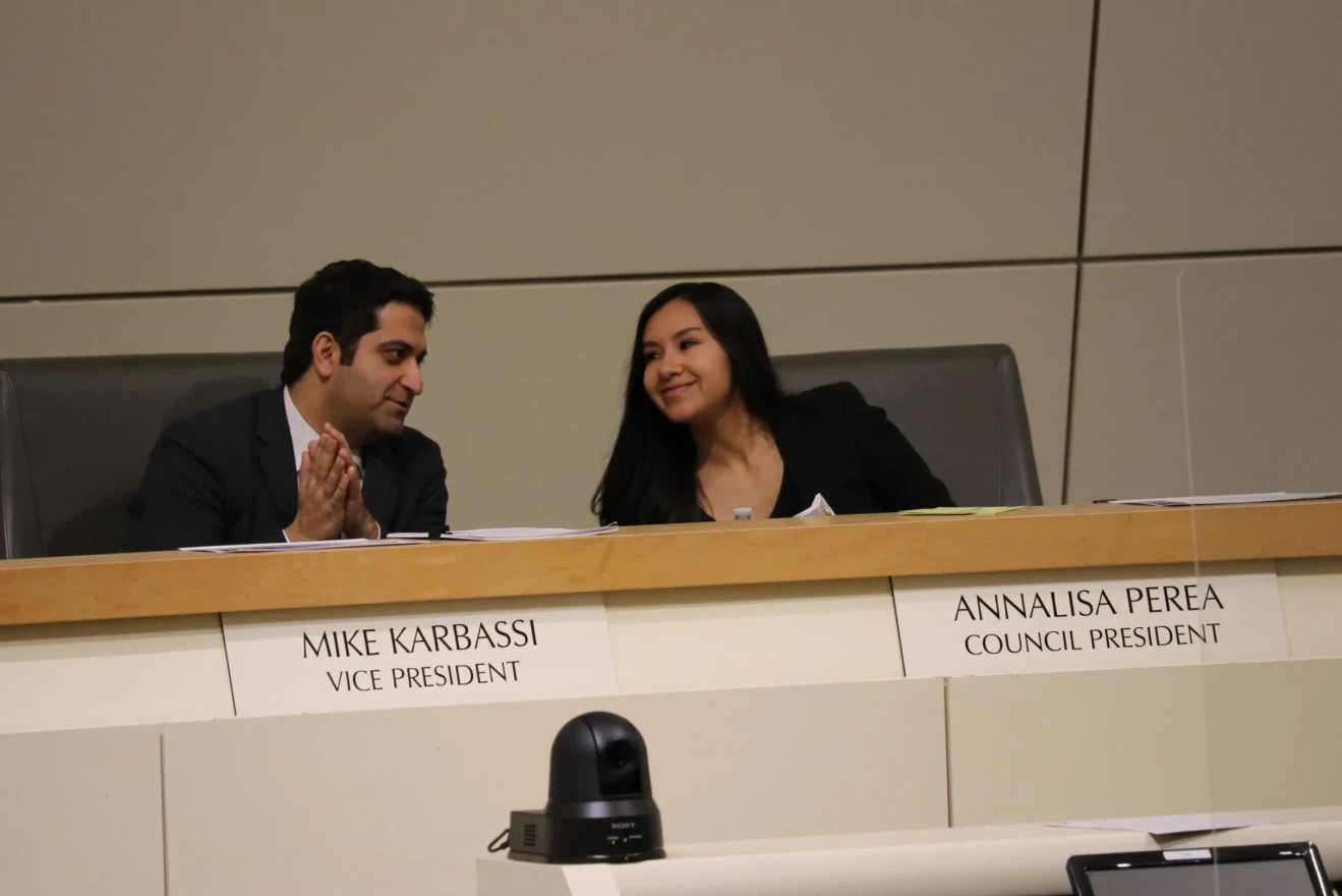 Council President Annalisa Perea and Vice President Mike Karbassi smile to each other on the dais at the Feb. 22 city council meeting. They co-sponsored a resolution to overhaul the council's process for establishing committees and wiggled in a method for councilmembers to create "informal working groups" exempt from rules for committees.